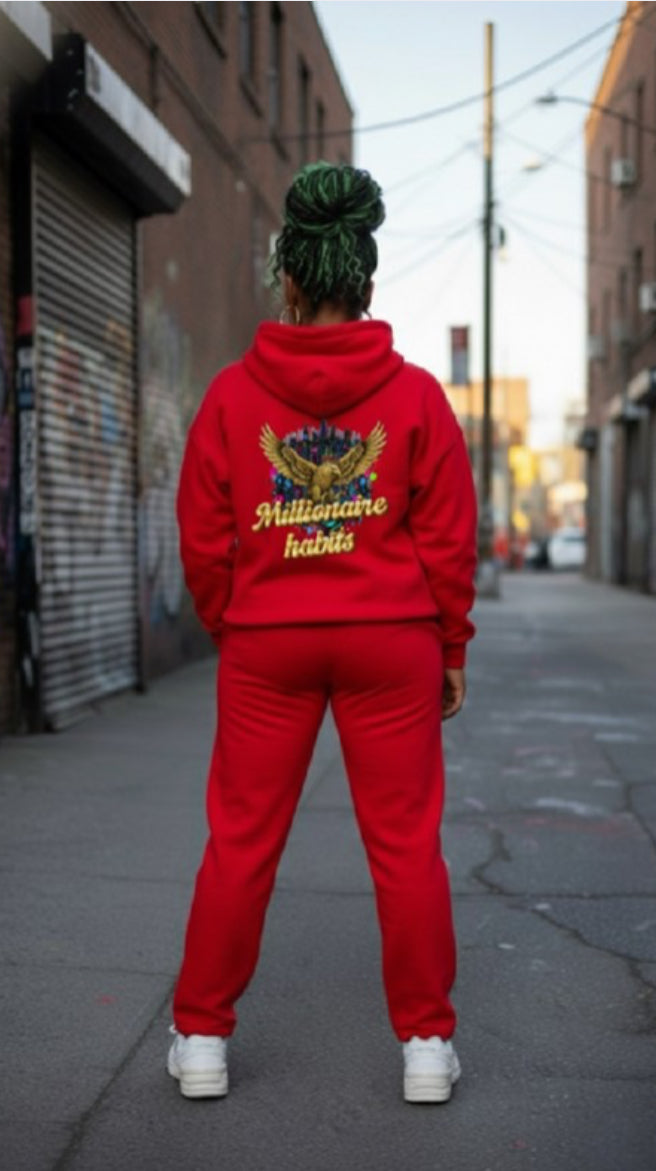 Person wearing Millionaire Habits- HOODIE in red, showcasing streetwear style on urban street.