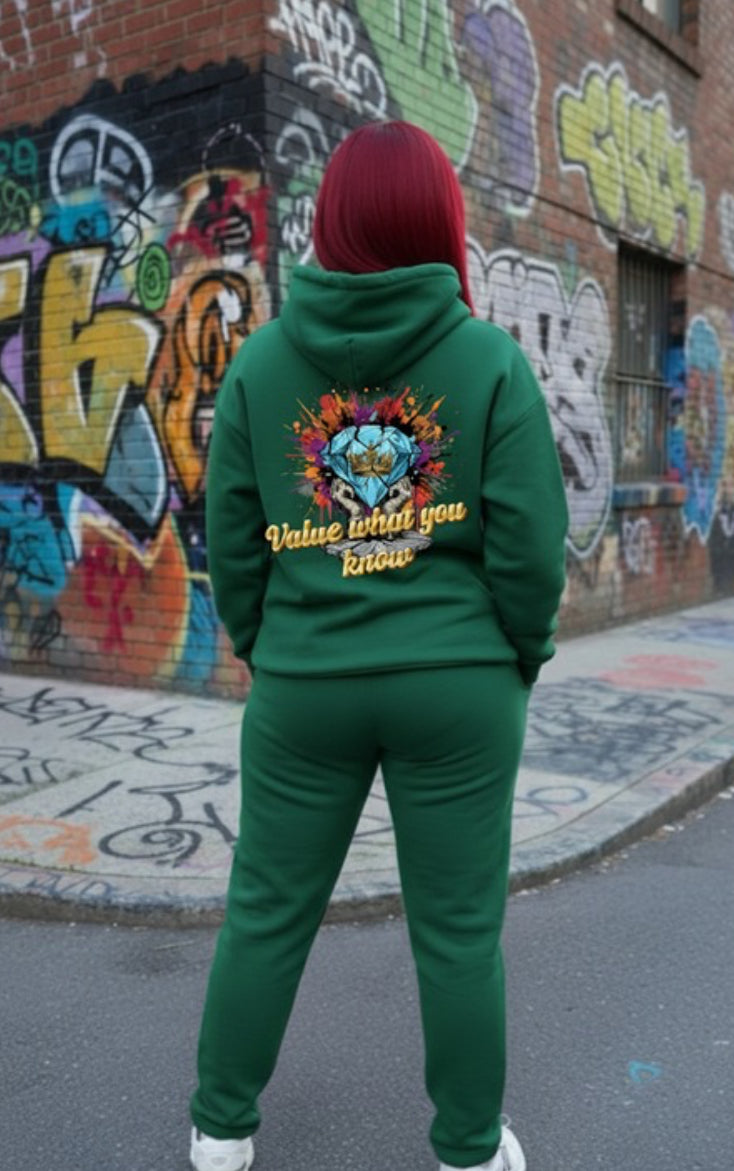 Value What You Know  - HOODIE displayed on a model in green against a colorful graffiti background, showcasing streetwear style.