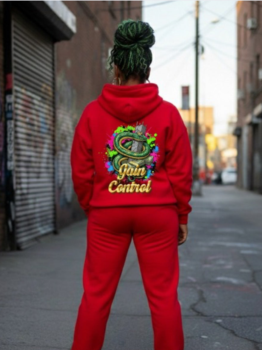 Gain Control- HOODIE in vibrant red worn by a person in an urban setting, showcasing streetwear style.