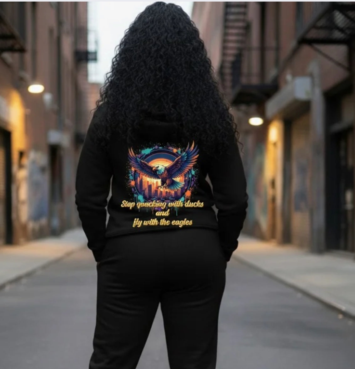 Fly With The Eagles- HOODIE worn by a woman in an urban setting, showcasing vibrant back design and streetwear style.