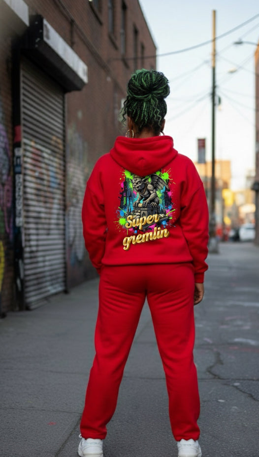 Person wearing a red Super Gremlin- HOODIE from the back in an urban setting, showcasing streetwear style.