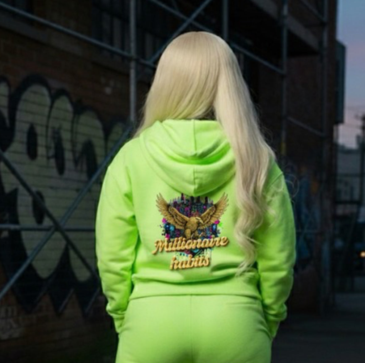 Model wearing a neon green Millionaire Habits- HOODIE showcasing streetwear style.