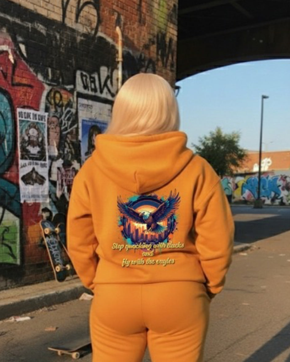 Fly With The Eagles- HOODIE displayed on a model against a vibrant street art backdrop showcasing urban streetwear style.